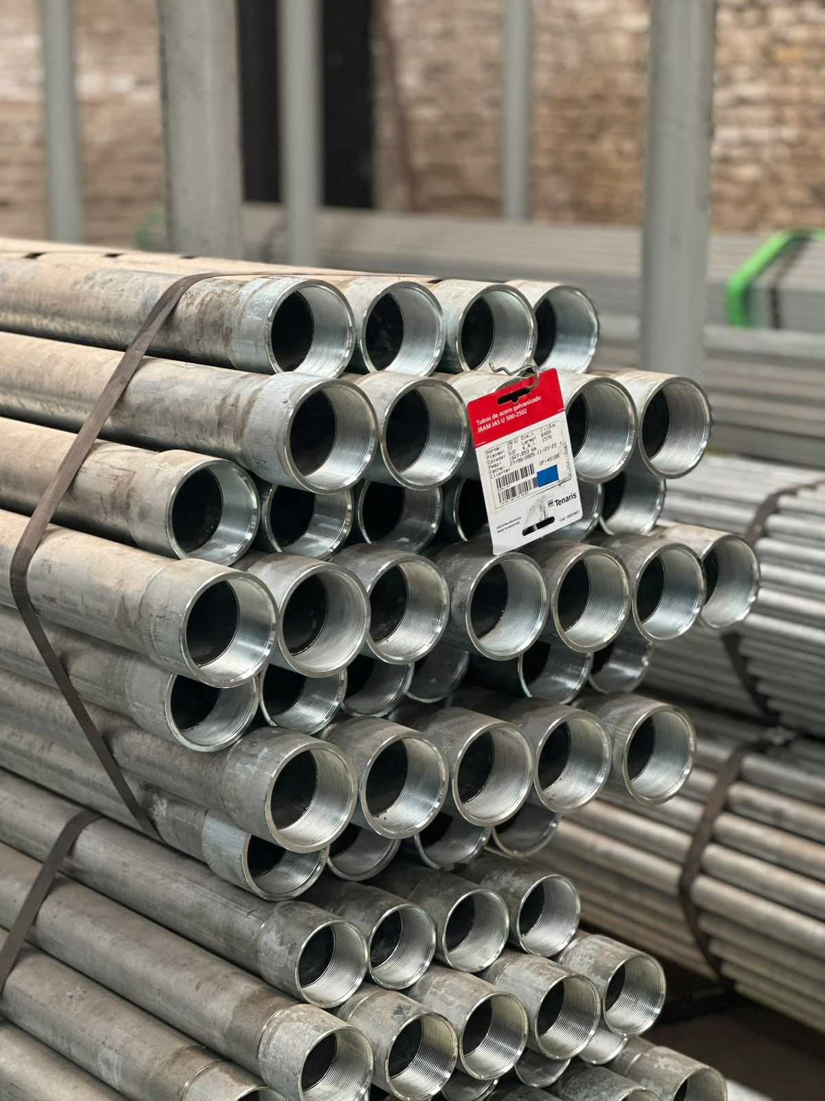 Pila de caños galvanizados con rosca y una etiqueta roja "Tubos de acero galvanizado IRAM IAS U 500-2502".