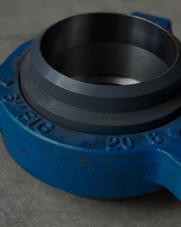 Unión doble a golpe azul de gran tamaño sobre un piso gris.